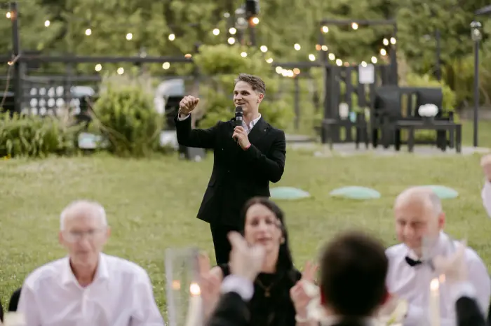Vladyslav with the guests under string lights