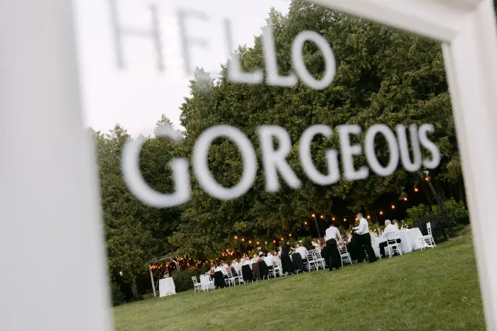 Hello Gorgeous sign over an outdoor reception