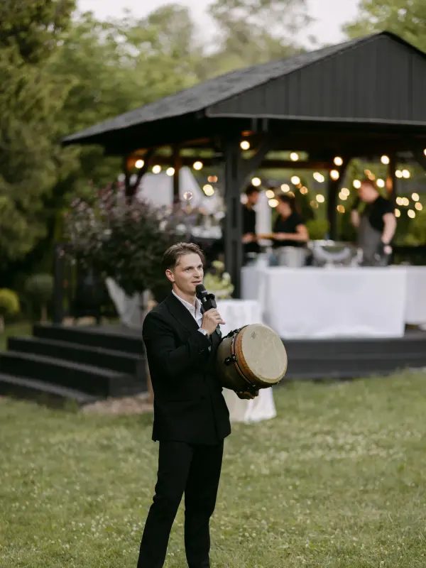 Vladyslav playing a hand drum outdoors