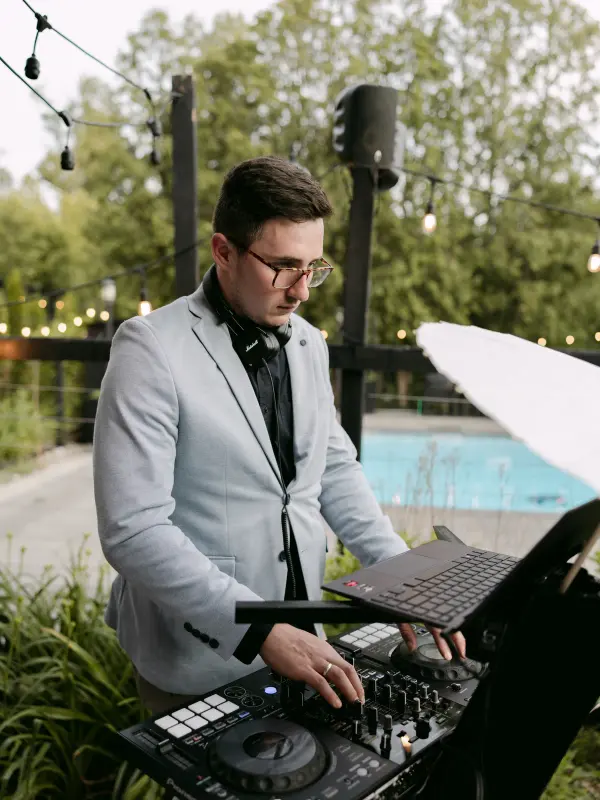 Vladyslav DJing at the laptop and controller, poolside