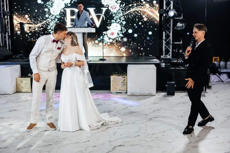 First dance in front of a sparkle wall while Vladyslav hosts